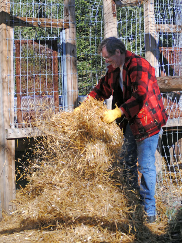 John spreads straw outside Ted's den