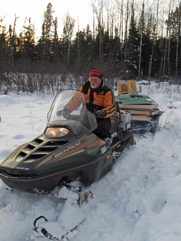 Lynn_driving_snowmobile_pulling_fish-house
